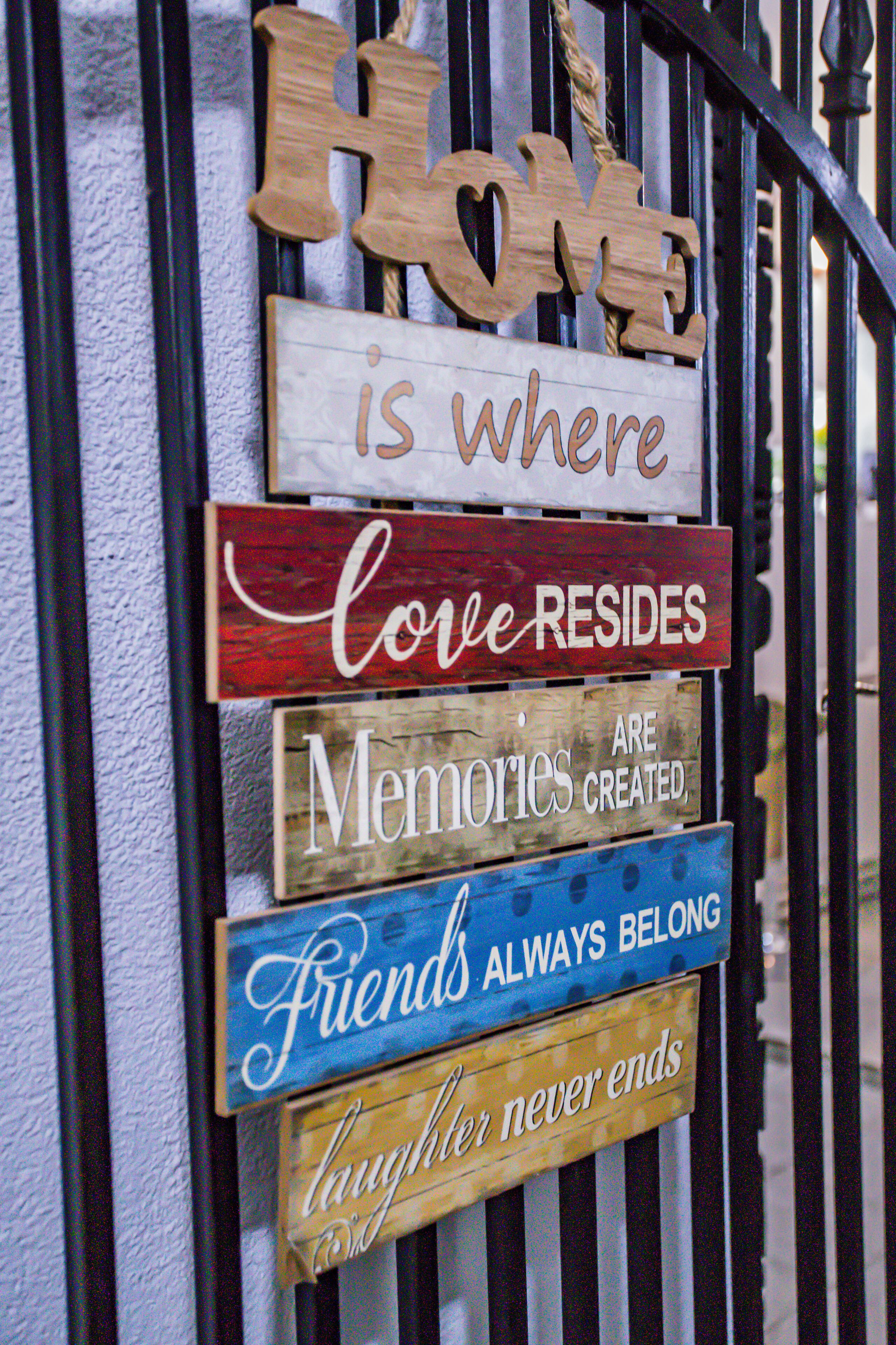 A collection of wooden signs with various messages about love, memories, and friendship.