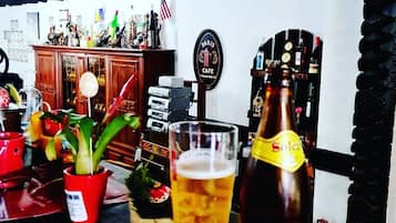 A bar area with a glass of beer, a Solcasa bottle, and a vintage jukebox.