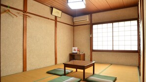 Una habitación japonesa tradicional con suelo de tatami, una mesa de madera baja y una ventana con pantalla shoji.