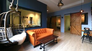 A modern living room with a sofa, a hanging chair, and a dining area with a table and chairs. - Adagio Bangkok (Bangkok)