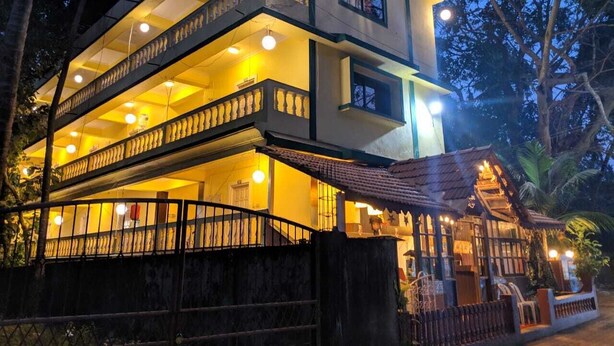 Un edificio de varios pisos con balcones y una zona cubierta con asientos.