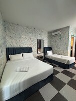 Habitación de hotel con dos camas, piso a cuadros, un espejo y un equipo de aire acondicionado.