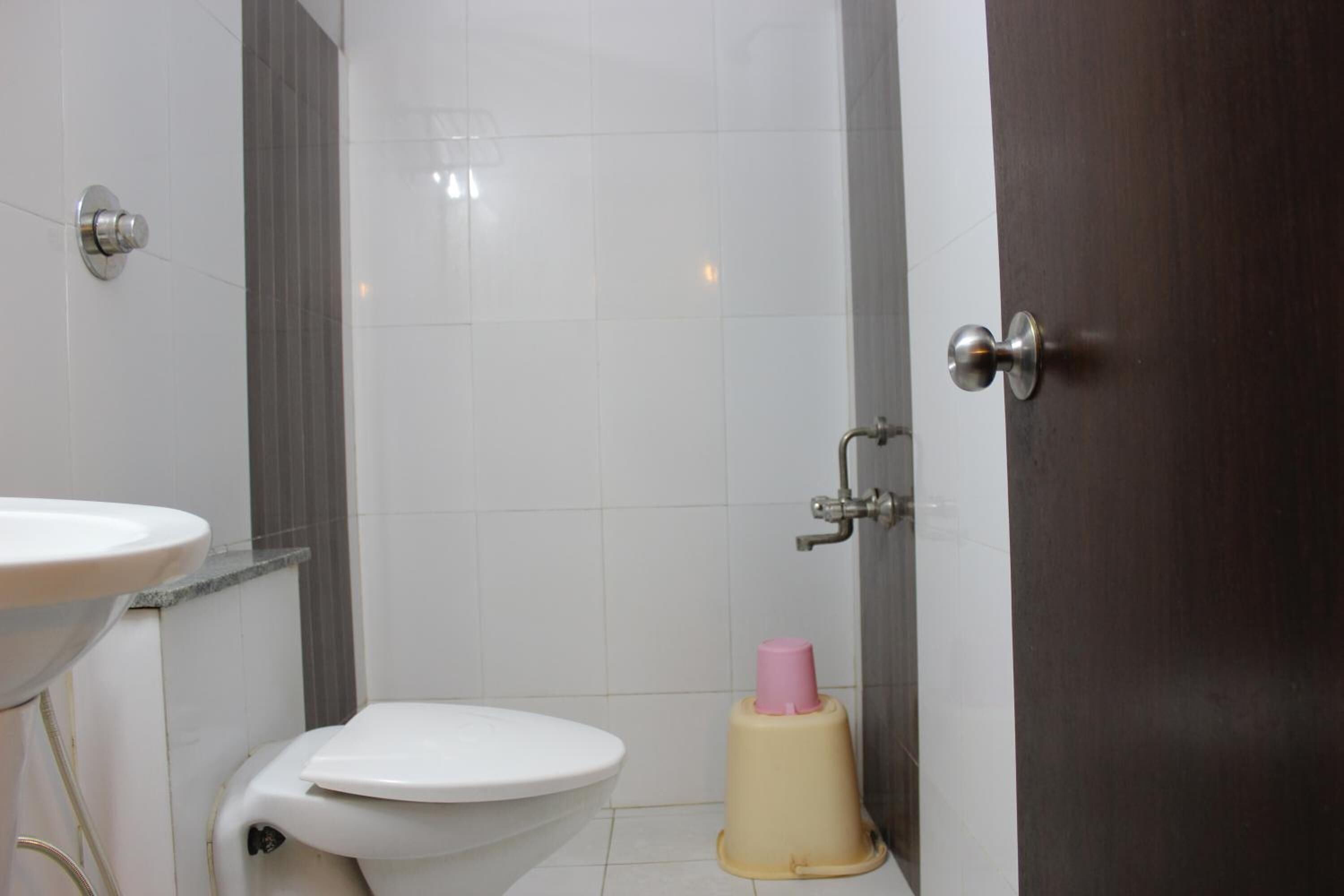 A bathroom with a white toilet, a sink, and a shower area.