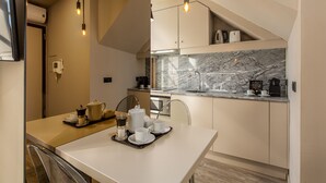 A modern kitchen with a marble countertop, a dining table with breakfast items, and pendant lights. - YOUROPO - Clérigos (Porto)