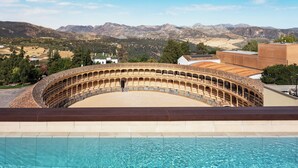 A swimming pool with a view of a historic amphitheater and mountains in the background. - Catalonia Ronda (Ronda)
