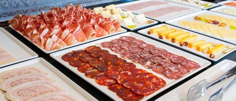 A buffet with various meats and cheeses.