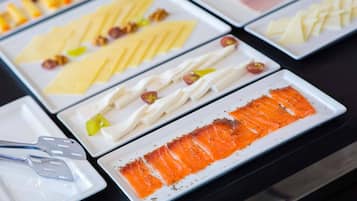 A buffet with various food items including salmon, cheese, and other dishes.