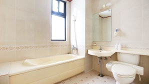 A bathroom with a bathtub, sink, toilet, and a window. - Venus Motel&Pension (Boryeong)