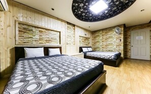 A hotel room with two beds, wooden walls, a stone accent wall, a ceiling fan, and a door with a sign. - Venus Motel&Pension (Boryeong)