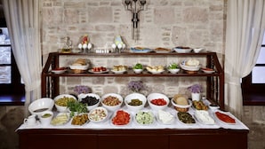 Une table de buffet garnie de divers plats et un mur décoratif agrémenté d’un chandelier.