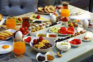 Et morgenbord med forskellige retter, blandt andet æg, ristet brød, frugt og drikkevarer.