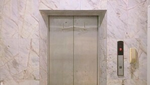 An elevator with marble walls and a digital display showing the number 3. - Boon Street Hostel (Bangkok)