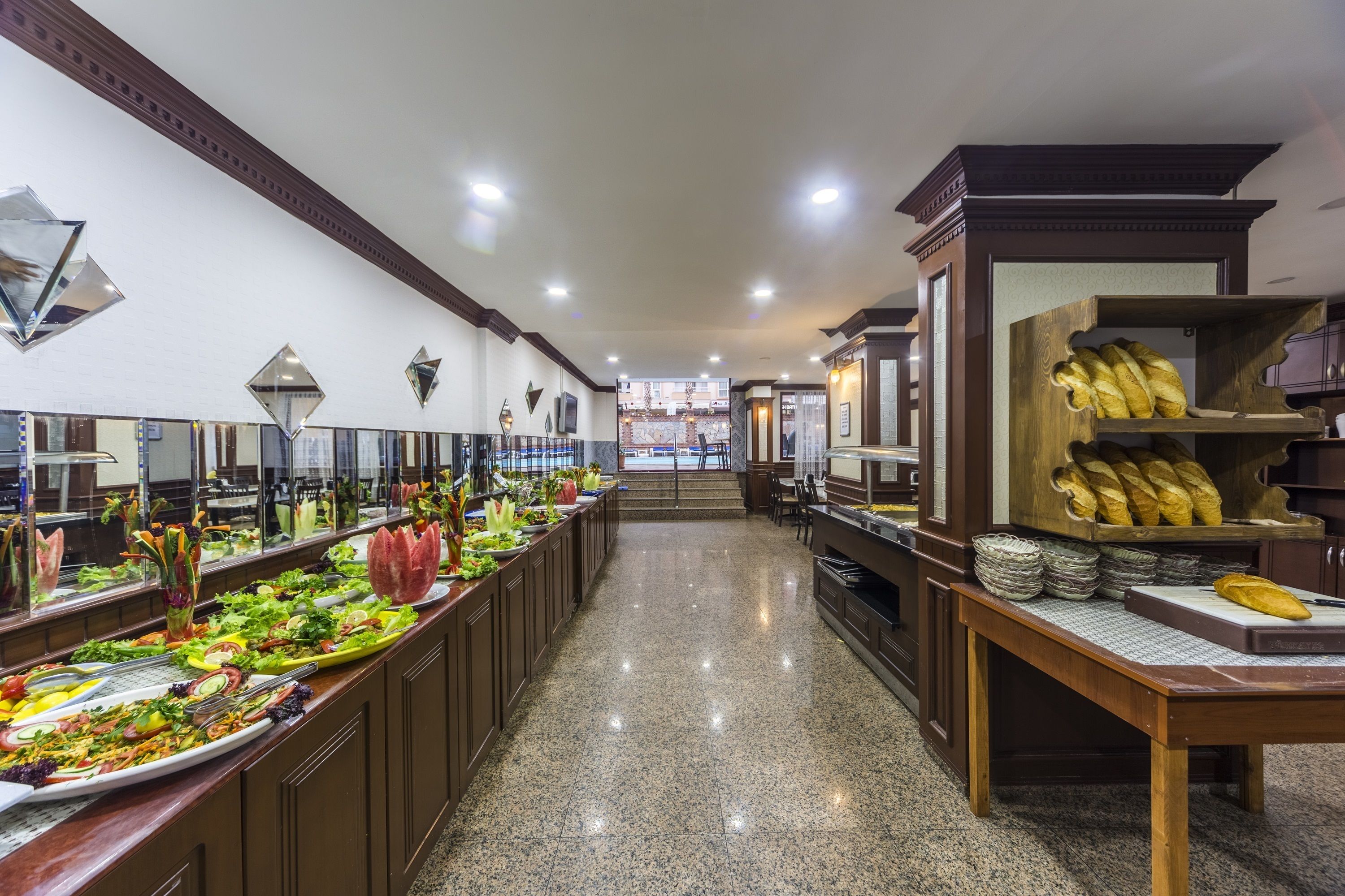 A buffet area with a variety of food items, including salads, bread, and other dishes.