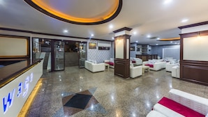 A hotel lobby with a reception desk, seating area, and a staircase leading to an upper floor. - Wasa Hotel (Alanya)