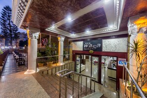 Entrada de un hotel con escaleras, columnas y un letrero que dice 'Wasa Hotel'.