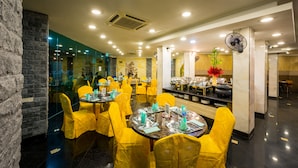 Een restaurant met ronde tafels, gele stoelen en een modern interieur.