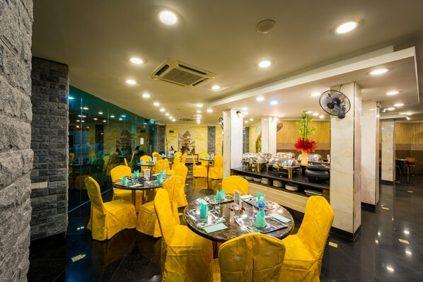 A restaurant with round tables, yellow chairs, and a modern interior.