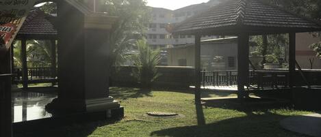 A courtyard with a gazebo, a pool, and a sign for a restaurant.