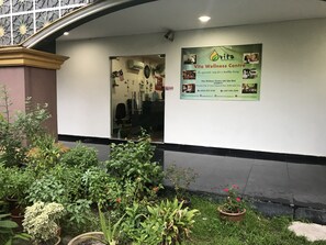 A wellness center with a signboard, indoor plants, and a small garden area. - AB Inn Hotel (Senai)