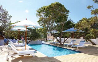 Una piscina al aire libre, sillones reclinables de piscina