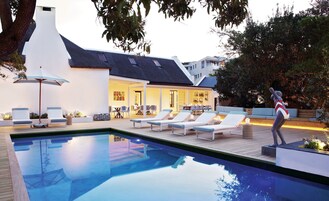 Una piscina al aire libre, sillones reclinables de piscina
