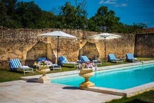 Una piscina al aire libre de temporada, sombrillas