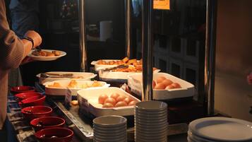 A buffet setup with various food items and bowls.