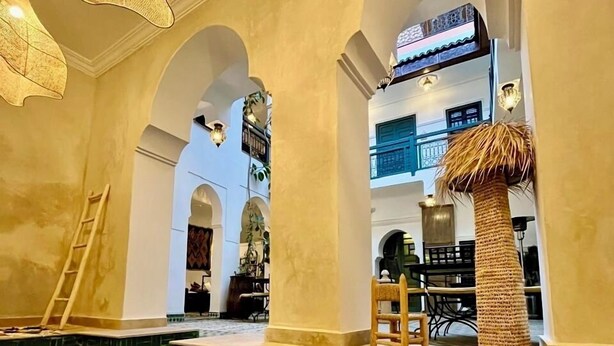 A pool area with clear water, arched ceilings, and hanging light fixtures. - Riad Ecila (Marrakech)