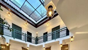 A spacious courtyard with a high ceiling, multiple seating areas, and a central fountain. - Riad Ecila (Marrakech)