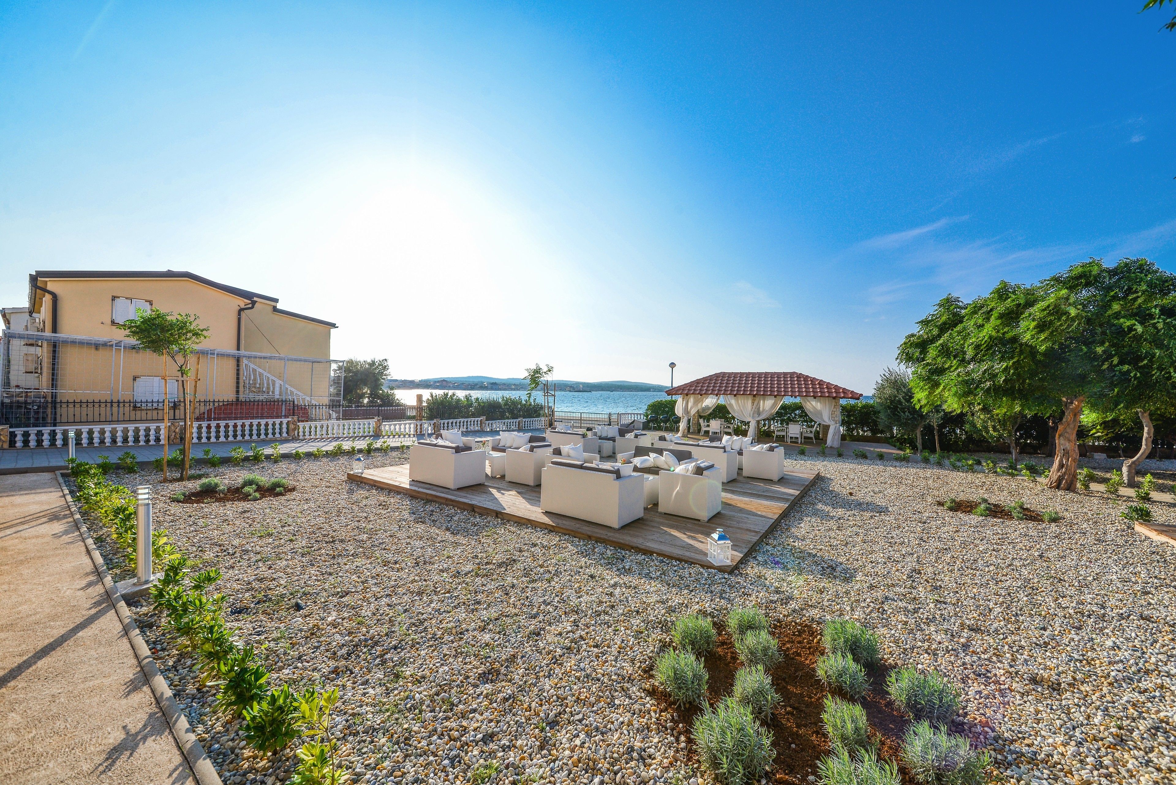 Eine Dachterrasse mit Sitzgelegenheiten im Freien, einem Pool und Blick auf das Meer.