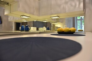 Eine moderne Küche mit einem großen Spiegel, einer Zitronenschale und blauem Küchengeschirr.
