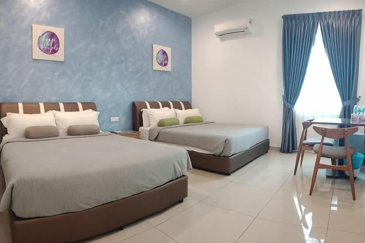 Une chambre d’hôtel avec deux lits, un bureau et une chaise.