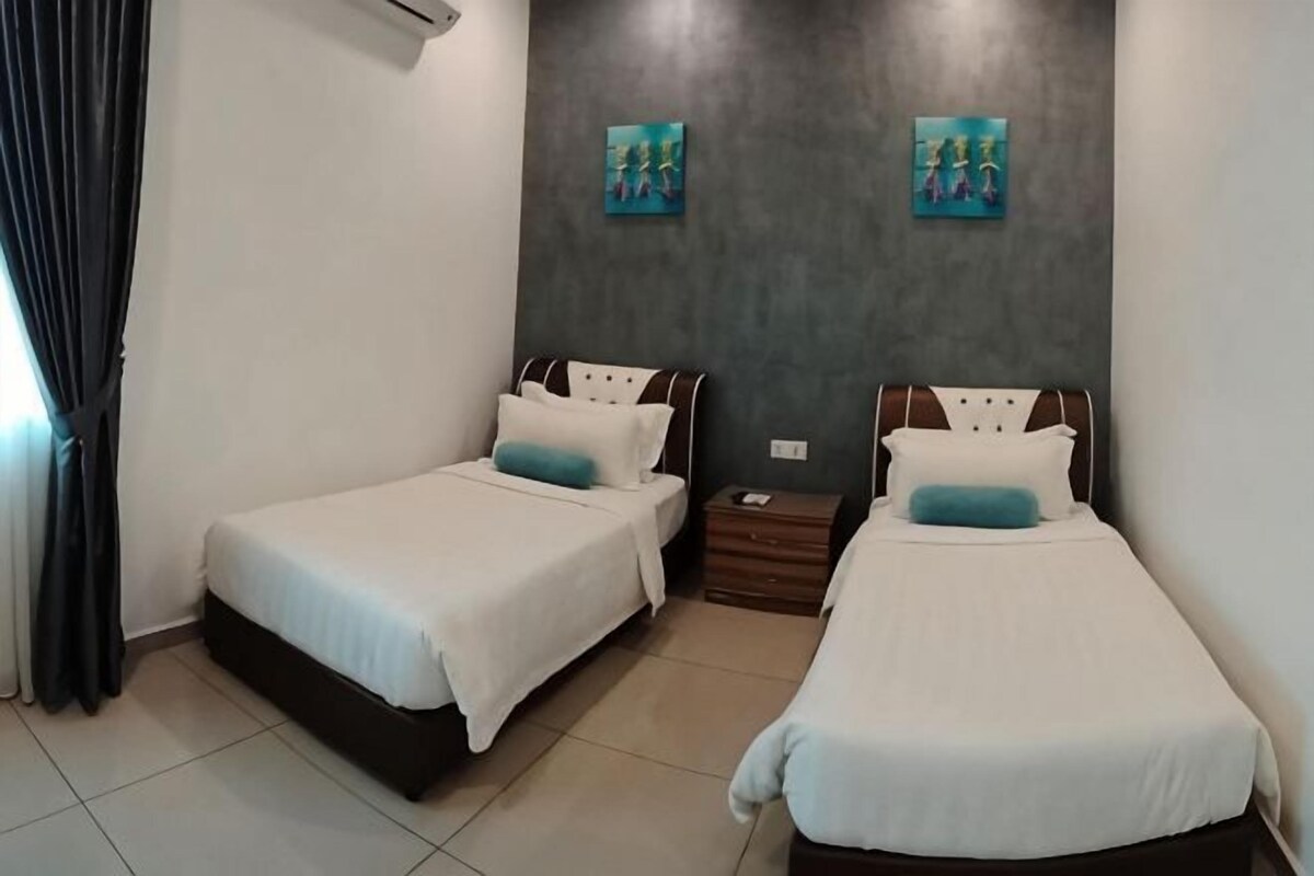 A hotel room with two beds, a nightstand, and artwork on the wall.