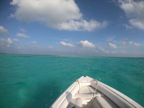 A boat on turquoise water with a clear sky.