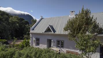 A house with a sloped roof, a chimney, and a door leading to a porch.