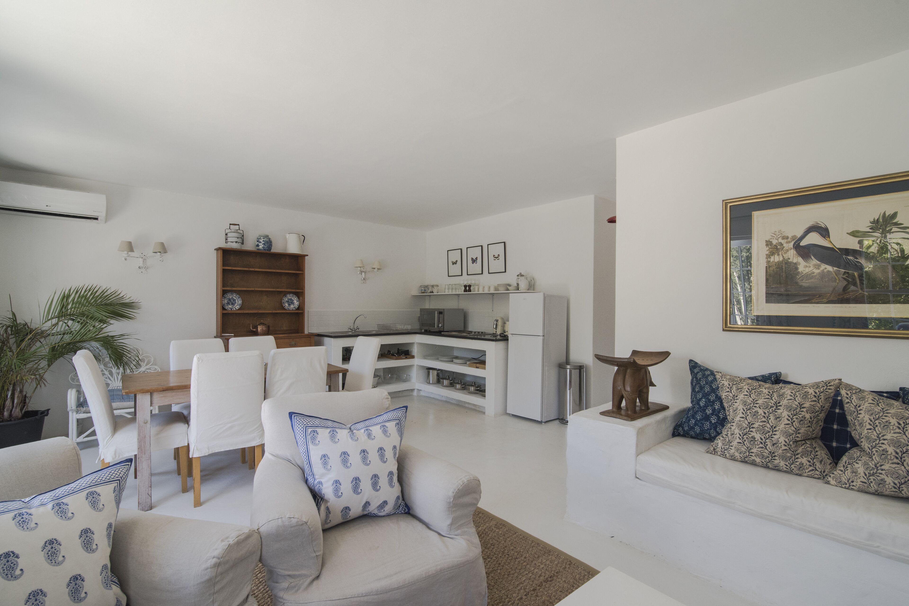 Ein modernes Wohnzimmer mit Essbereich, einer Küche und einem Esstisch mit Stühlen.