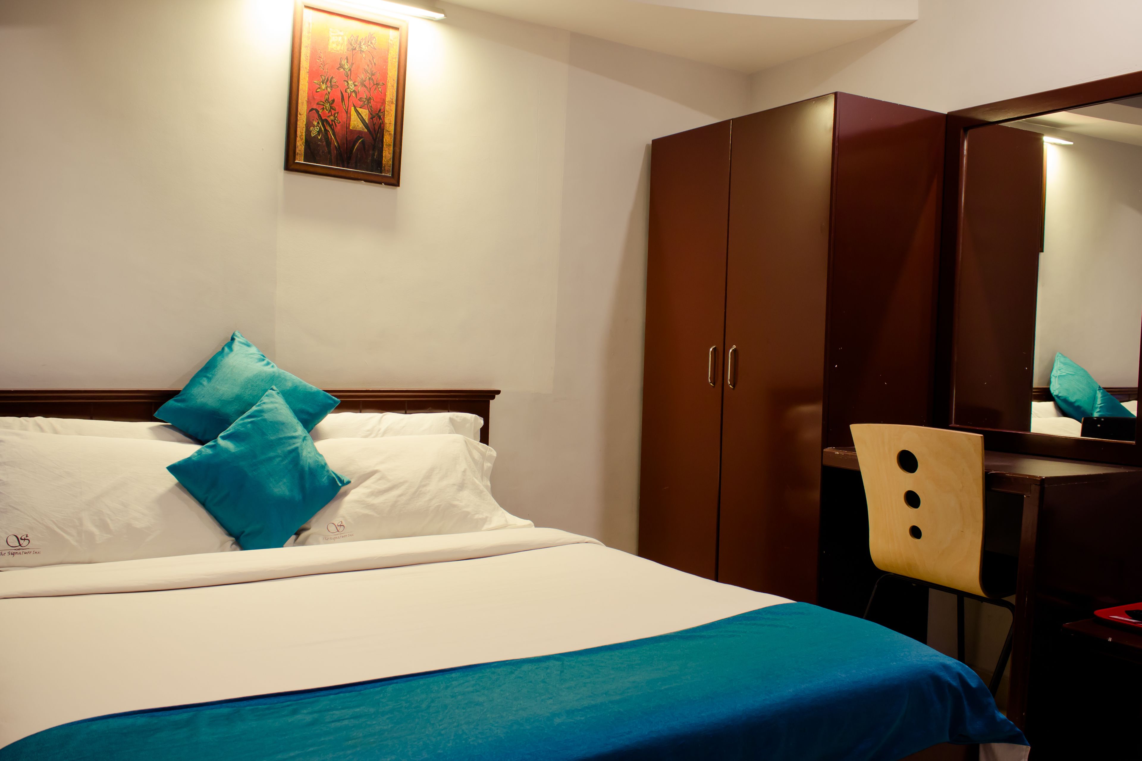 Una habitación de hotel con una cama, un escritorio y una silla.