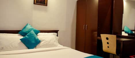 Una habitación de hotel con una cama, un escritorio y una silla.