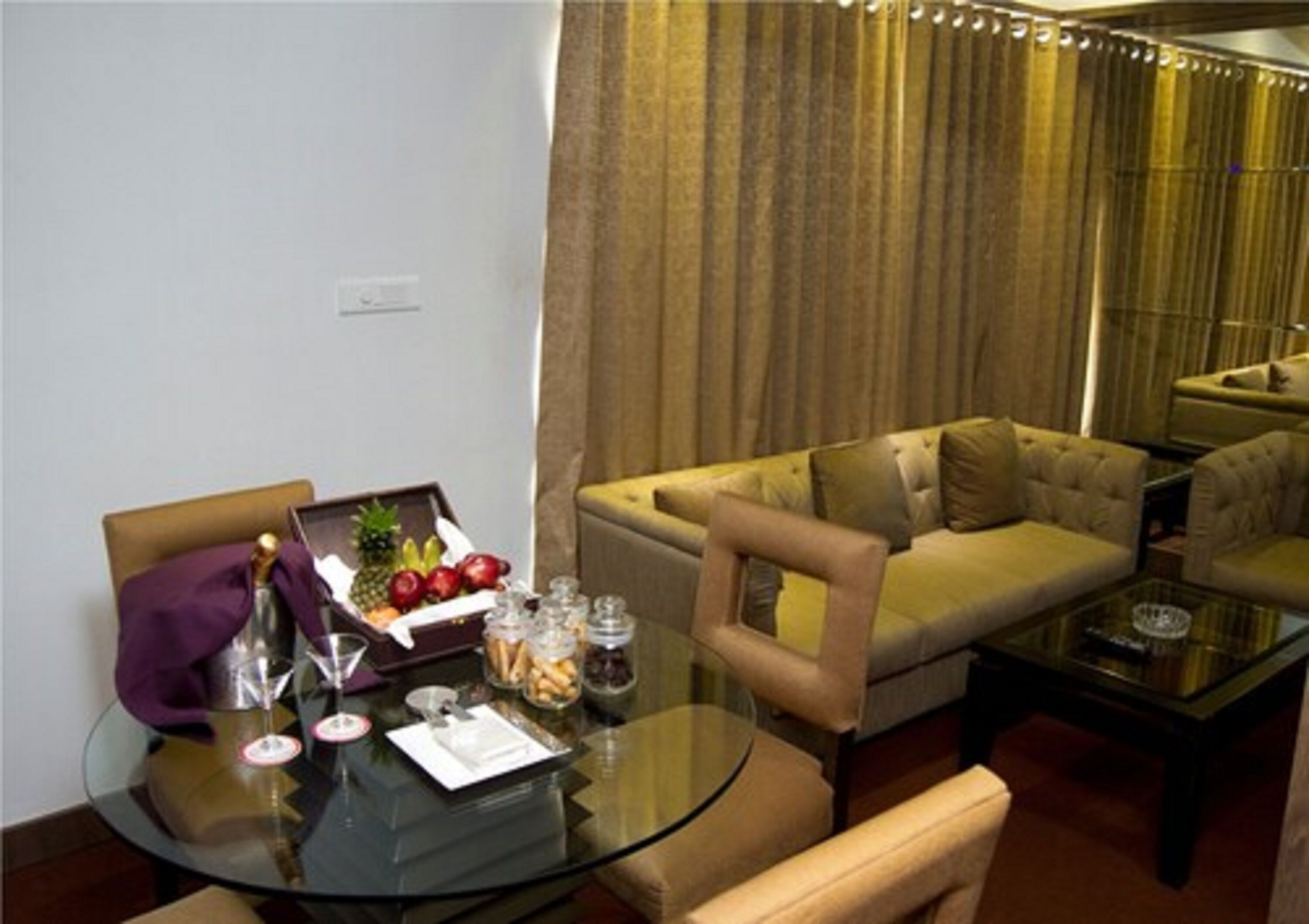 Una sala moderna con una mesa de centro de vidrio, un sofá color beige y un comedor con una mesa de vidrio.