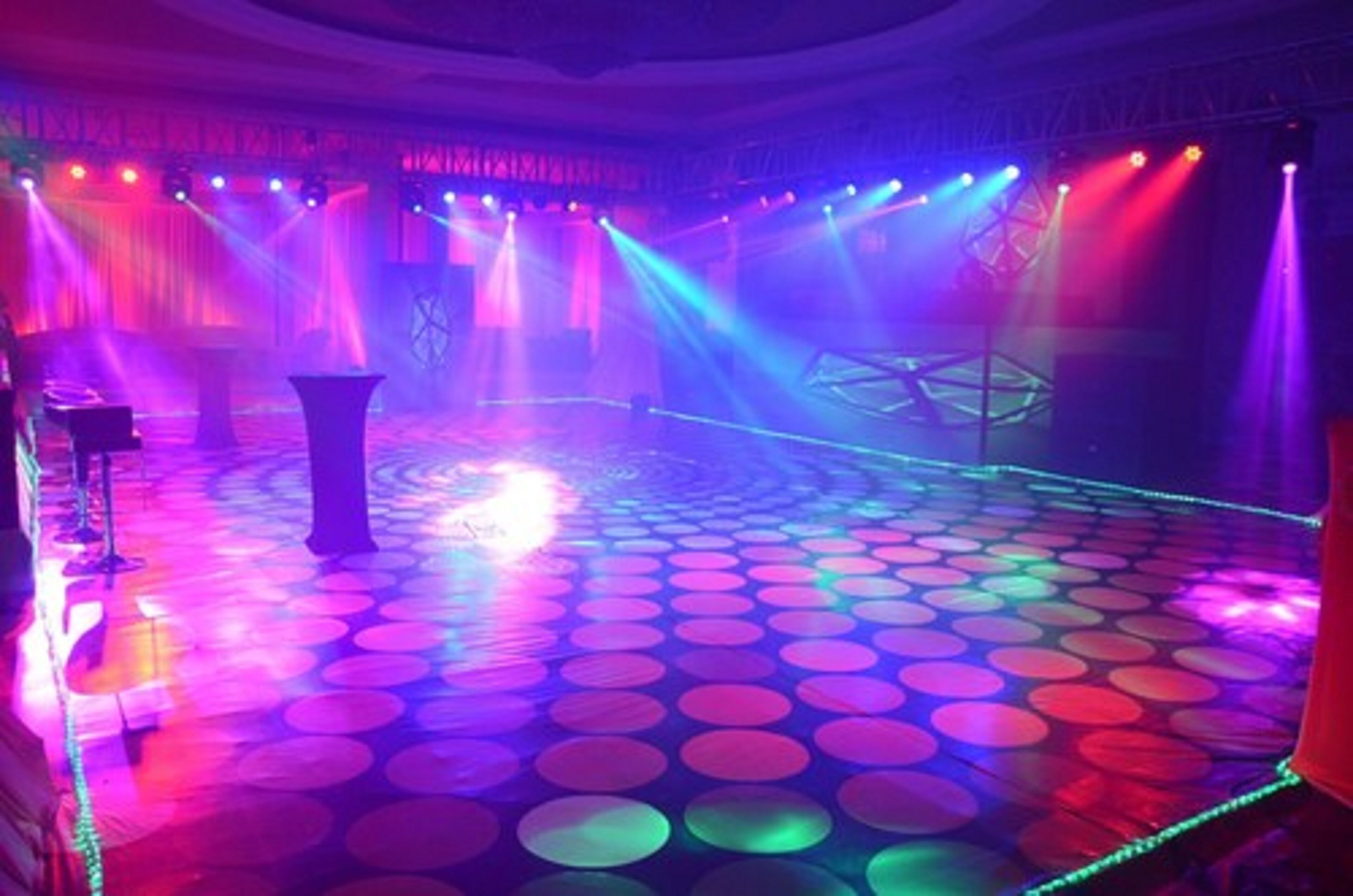 Un escenario con piso de diseño circular y luces de escenario coloridas.