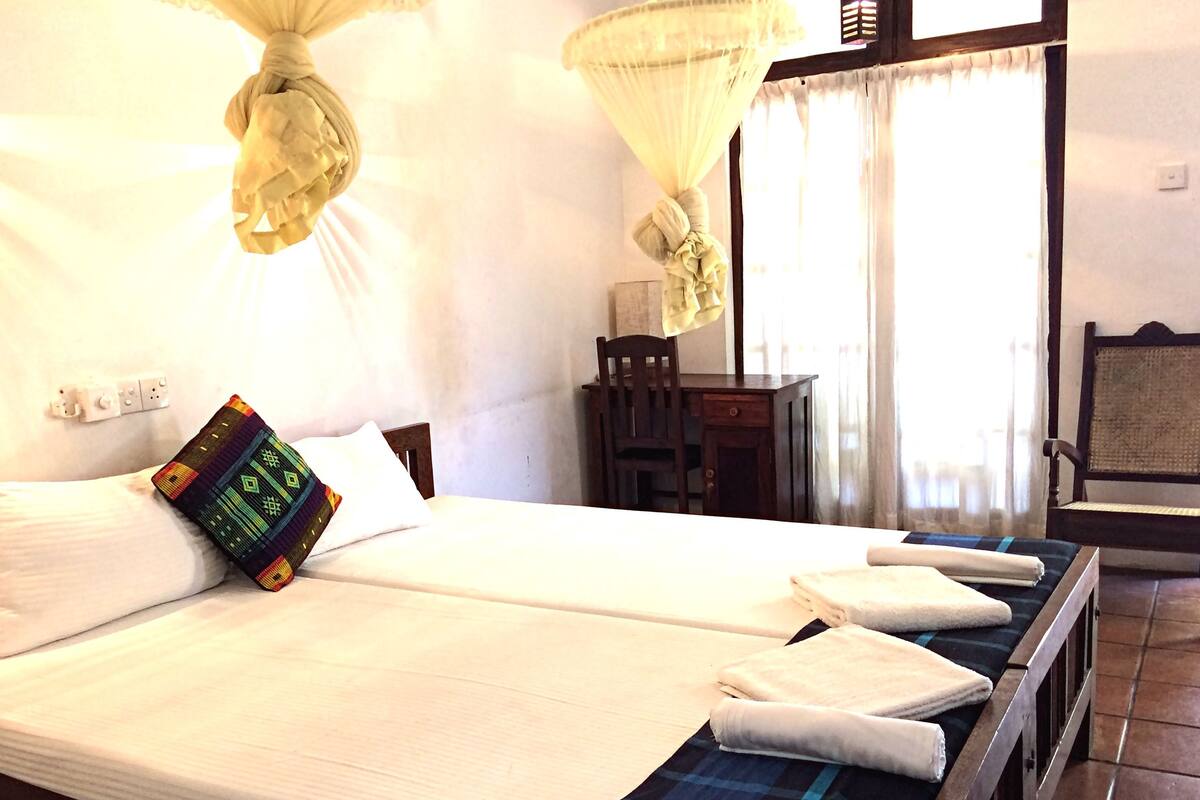 A hotel room with a bed, a desk, and a chair.