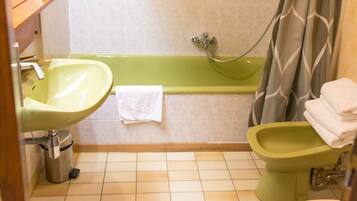 A bathroom with a green bathtub, a green sink, and a toilet.