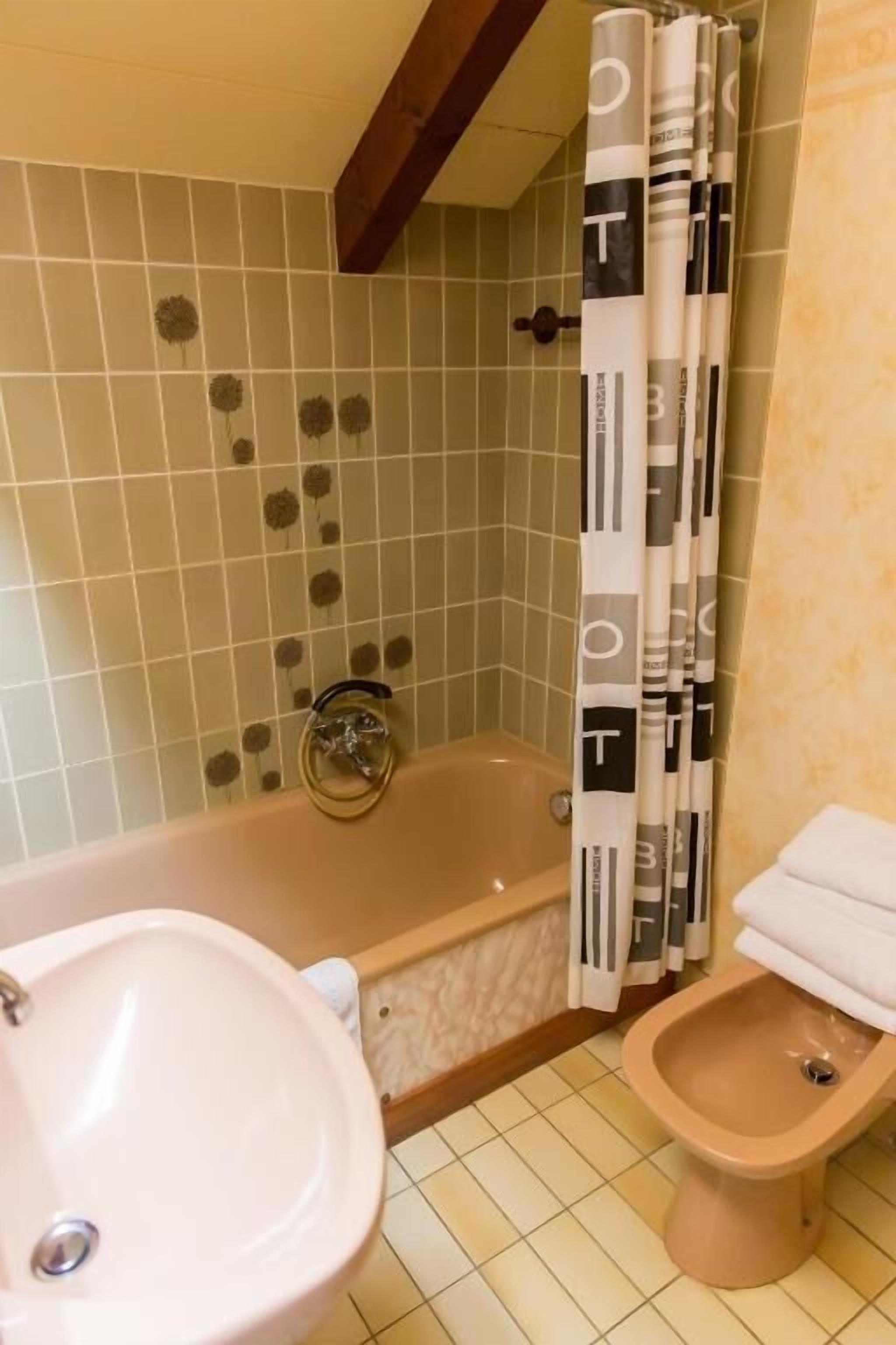 A bathroom with a bathtub, a sink, and a bidet.
