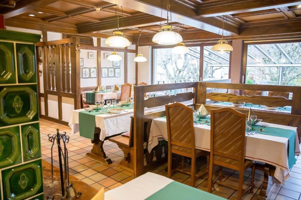 A restaurant with wooden furniture, green accents, and pendant lighting.