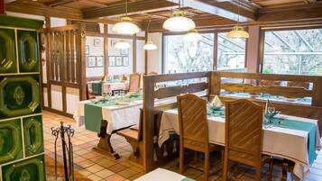 A restaurant with wooden furniture, green accents, and pendant lighting.