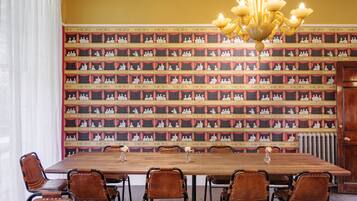 A conference room with a long table, brown leather chairs, and a wall of framed pictures.