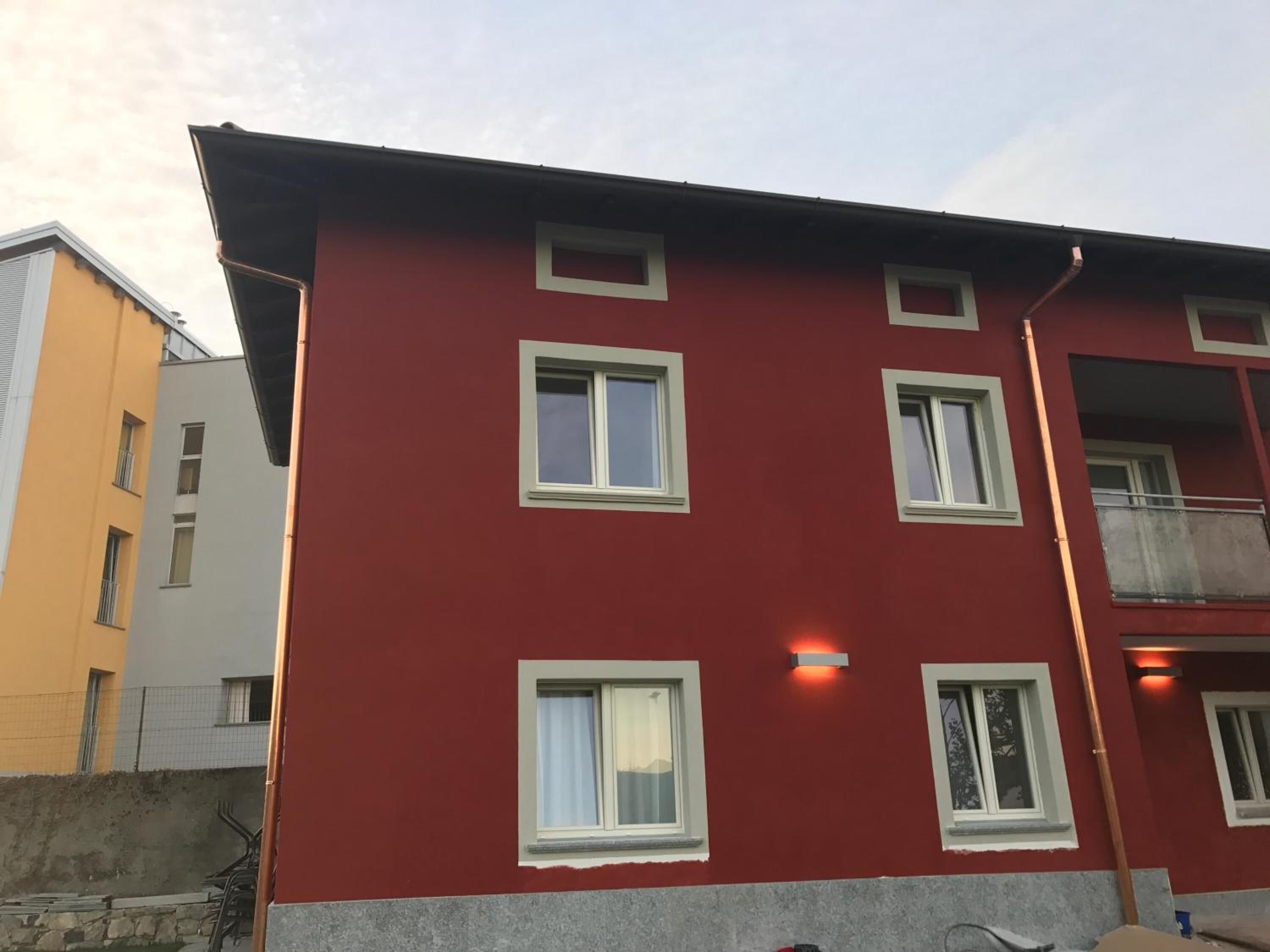 Un edificio rojo con varias ventanas y balcones.