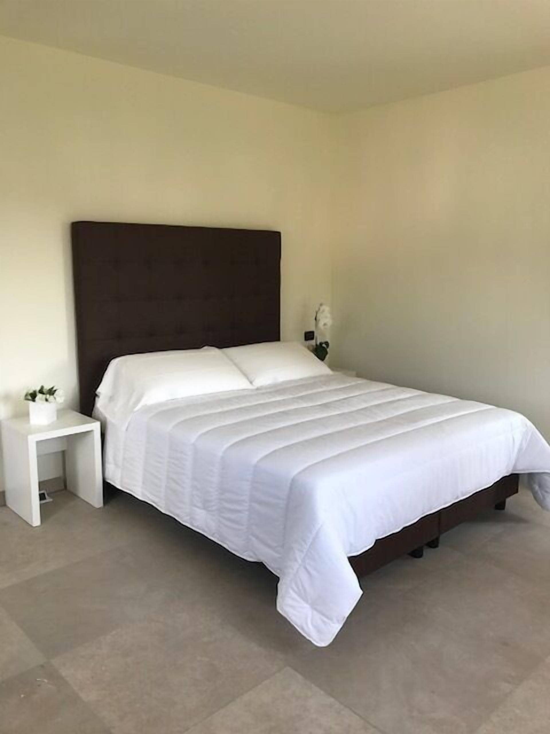 Une chambre à coucher avec un lit, une table de chevet et une lampe fixée au mur.