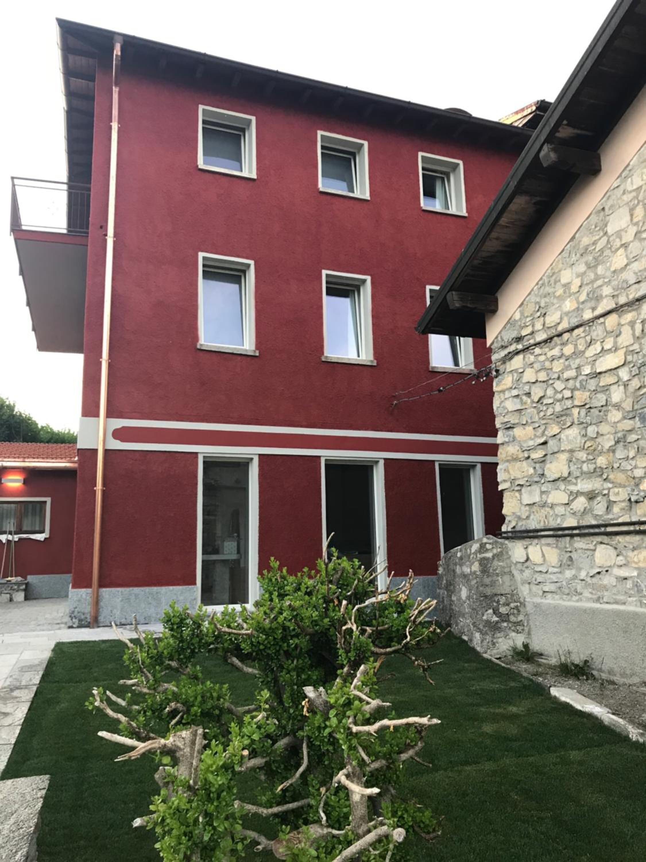 Un edificio rojo con varias ventanas y una pared de piedra.