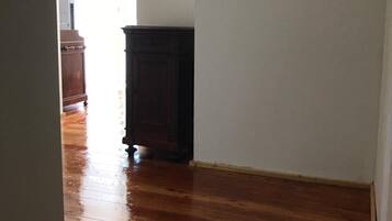 Un couloir doté d’un plancher en bois et d’une armoire en bois foncé.
